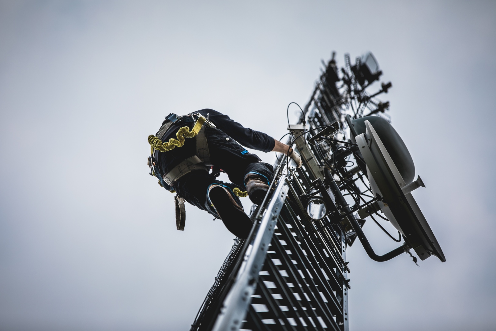 A man climbing up the side of a metal pole.